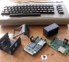 The Commodore 64, the disassembled 1541U case, its logo, screws and a pair of 1541 Ultimate boards.